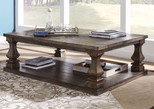 Side View of the Johnelle Coffee Table by Ashley Furniture with a Weathered Gray and Brown Finish in a Room Setting | Home Furniture Plus Mattress